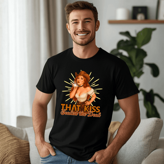 Man wearing a black Western-style t-shirt with a vintage cowgirl blowing a kiss and bold text “That Kiss Sealed the Deal” — flirty country shirt for men.