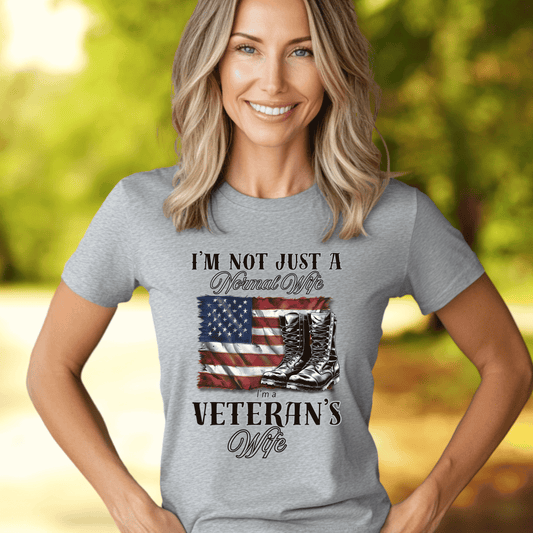 woman wearing gray patriotic t-shirt with flag and combat bookts that says Im not just a normal wife I'm a veteran's wife 