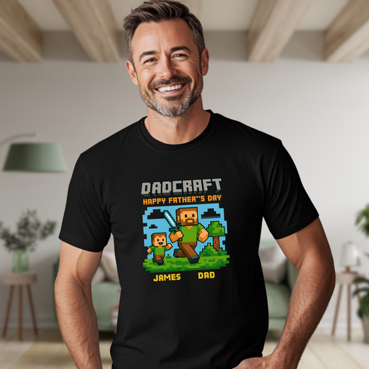 Smiling dad wearing a black t-shirt with a Minecraft-style pixel art design that says 'DadCraft – Happy Father's Day,' featuring a father and son running with a diamond sword and labeled 'James' and 'Dad.