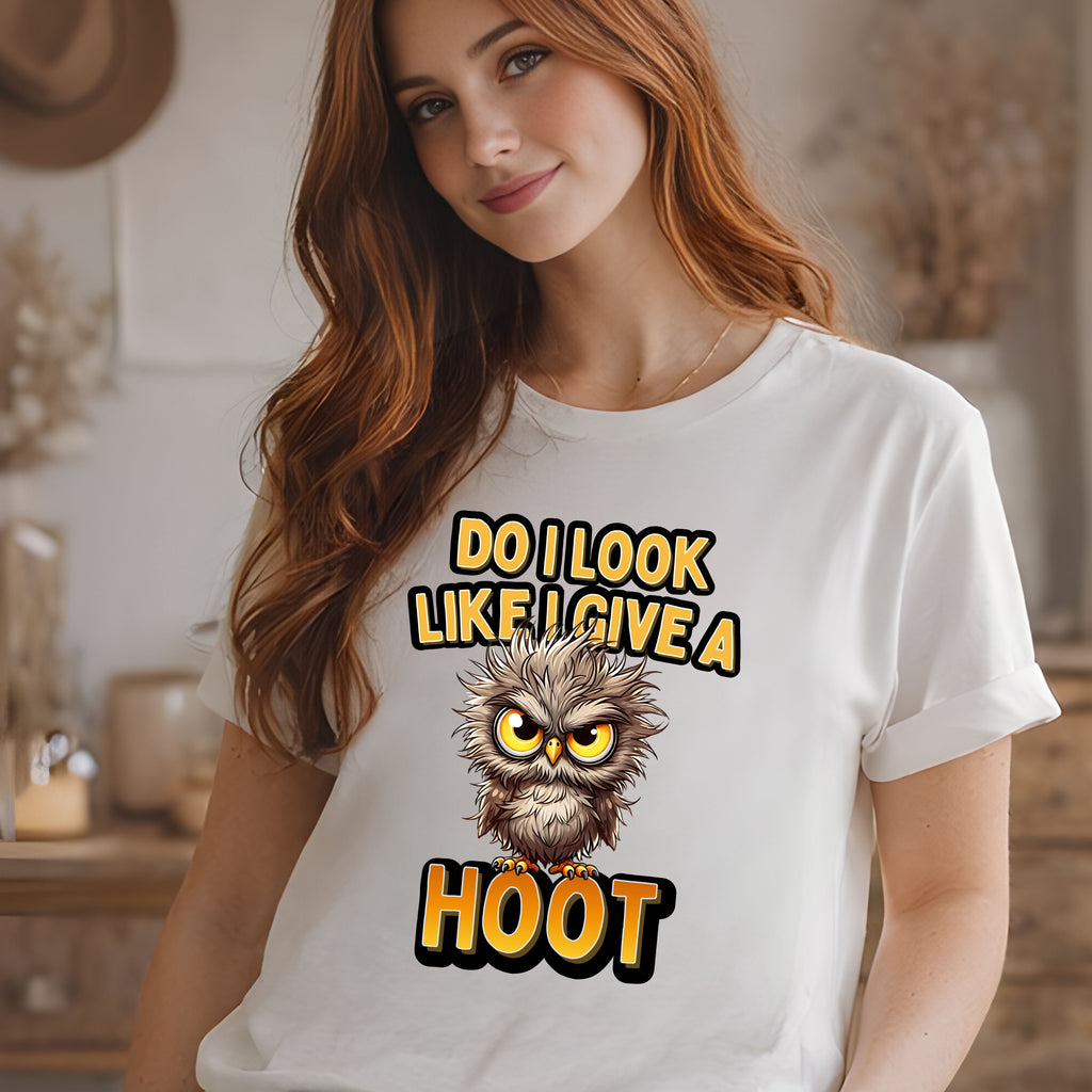 Woman wearing a white t-shirt with an owl graphic and text in a kitchen setting