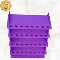 Purple multi-tiered organizer with holes on a textured white background