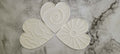 Set of four white ceramic coasters with decorative patterns on a marble surface