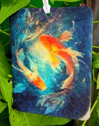 Decorative tag with a goldfish design hanging among green leaves