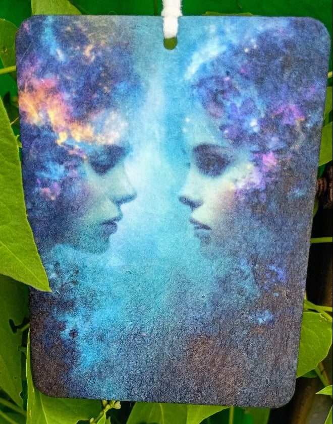 Decorative item with a cosmic design of two faces on a green leaf background