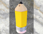 Yellow pencil-shaped bottle with black cap on a marble background