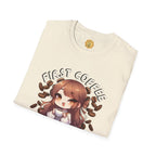 Folded cream-colored t-shirt with an anime character and 'First Coffee' text on a white background